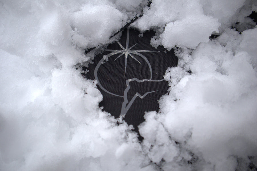 Polar Pursuit logo partially buried in snow