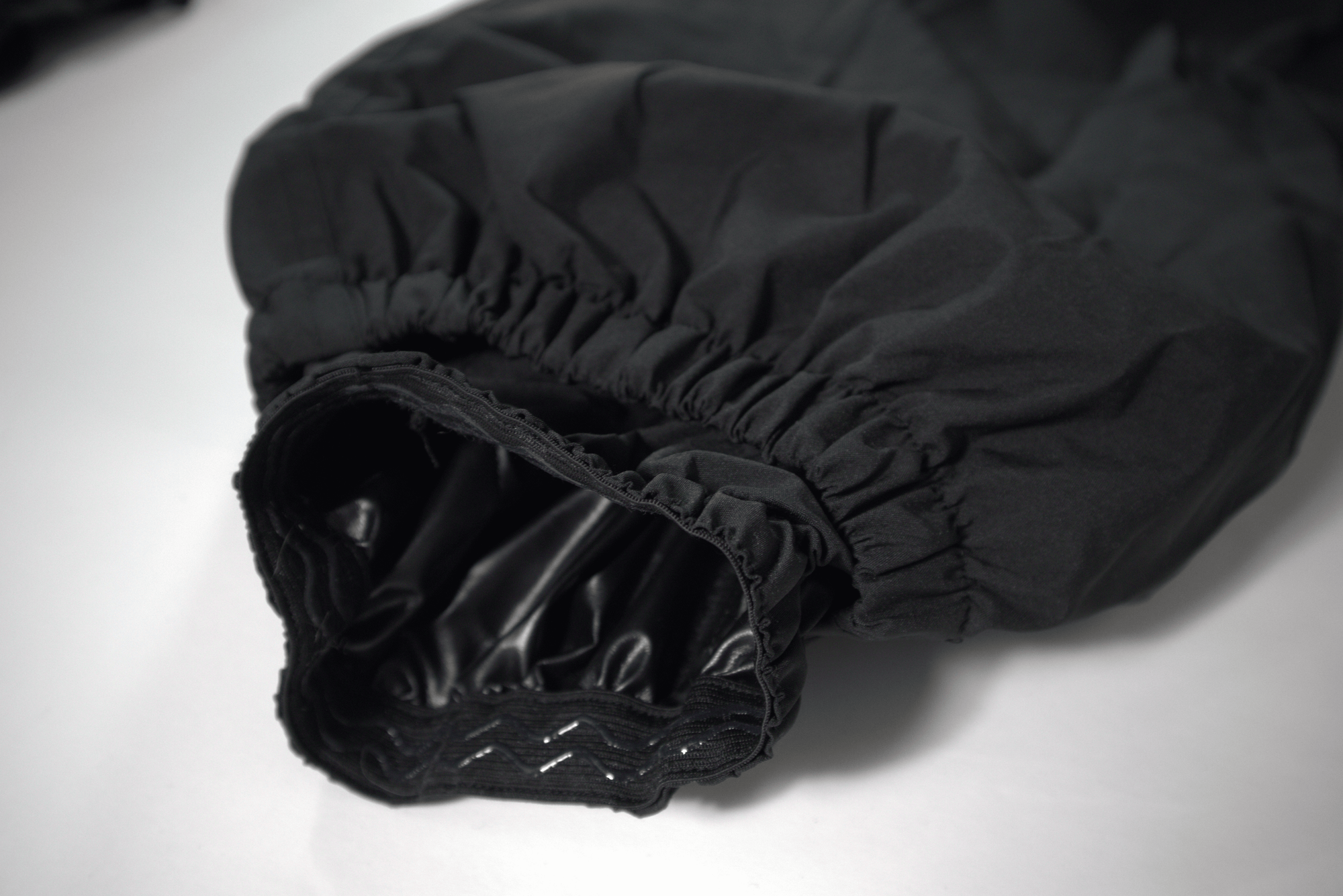 Black baggy snow pants close up on snow gathers on a white background