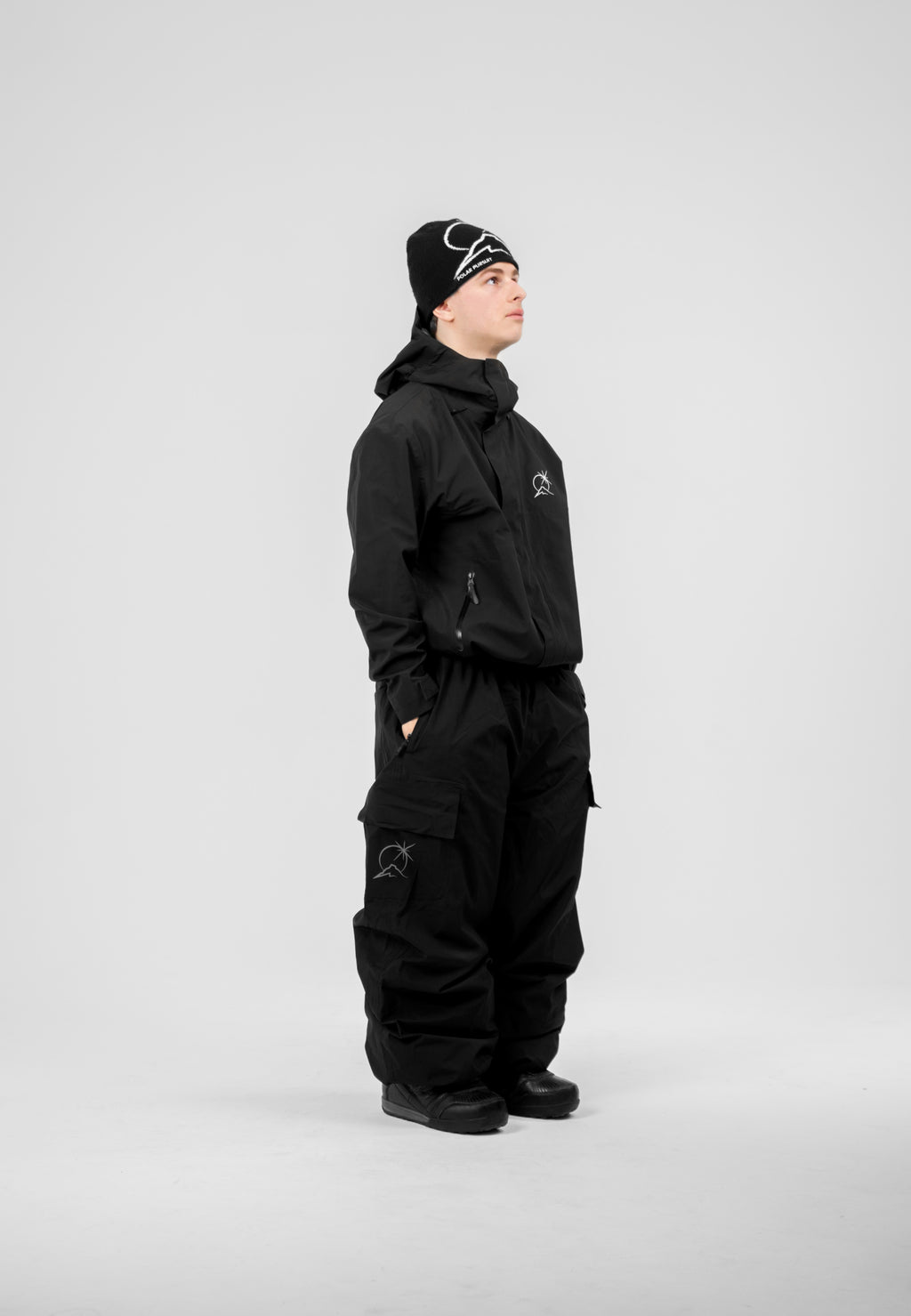 Person wearing a black Polar Pursuit snowsuiton a white background
