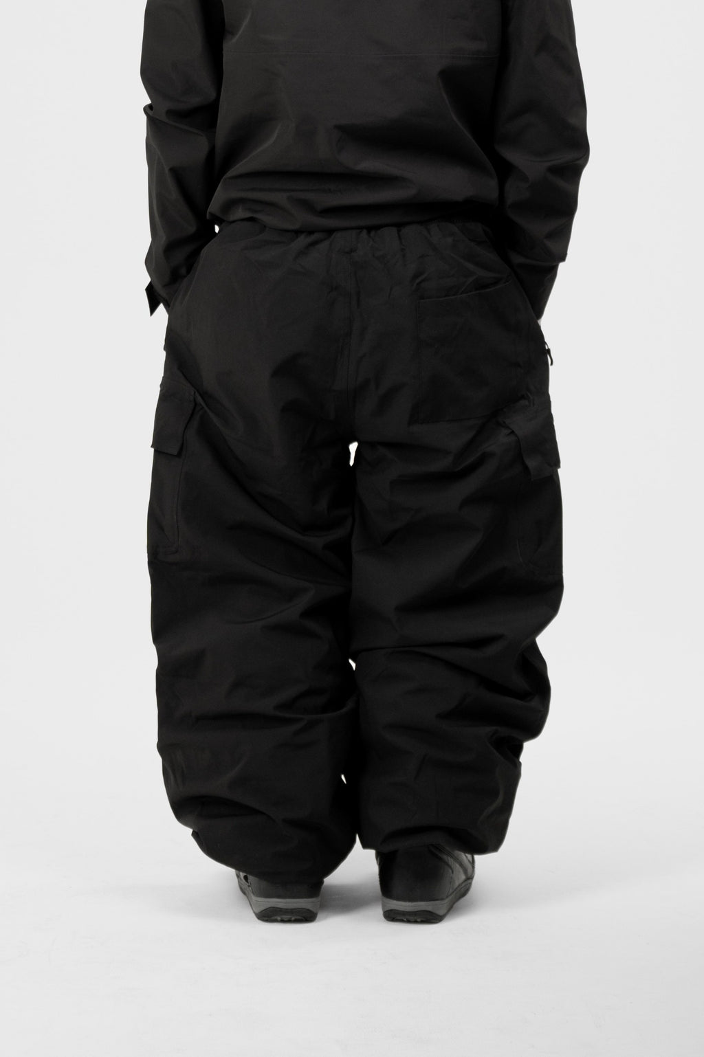 Person wearing a black Polar Pursuit snowsuiton a white background
