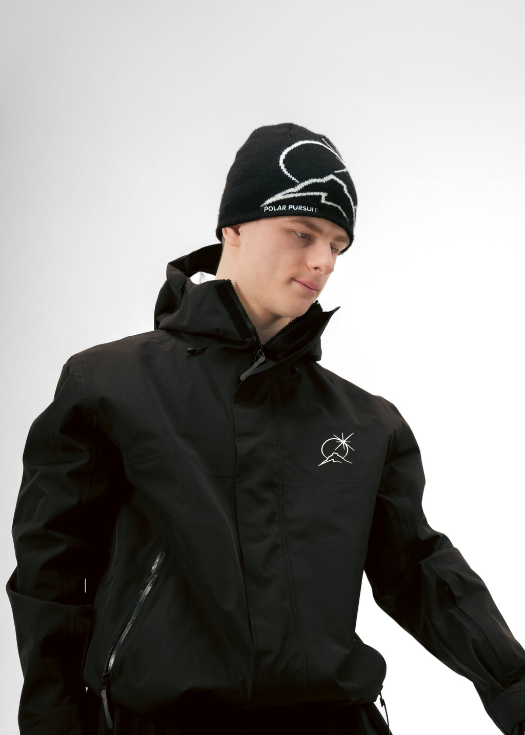 Person wearing a black Polar Pursuit jacket and Polar Pursuit beanie with visible branding on a white background