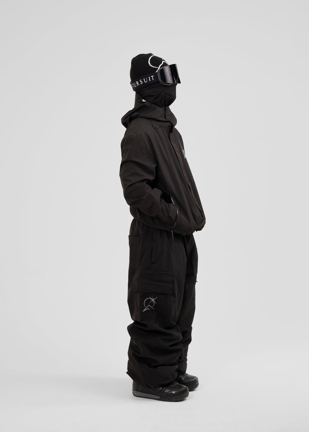 Person wearing a black polar pursuit snowsuit with a hood on a white background