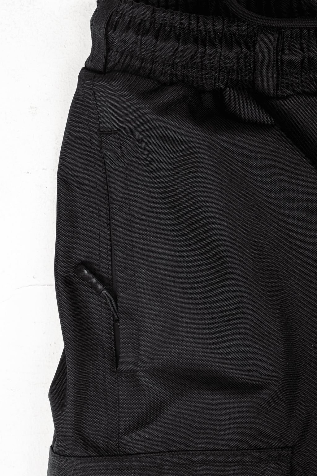 Close-up of a black Polar Pursuit snowpants with a pocket on a white background