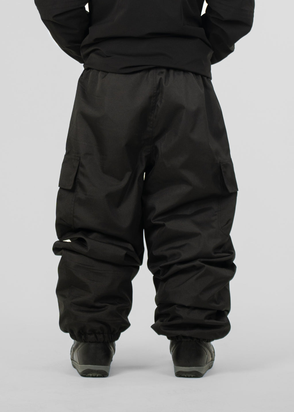 Person wearing black Polar Pursuit snowpants on a plain background