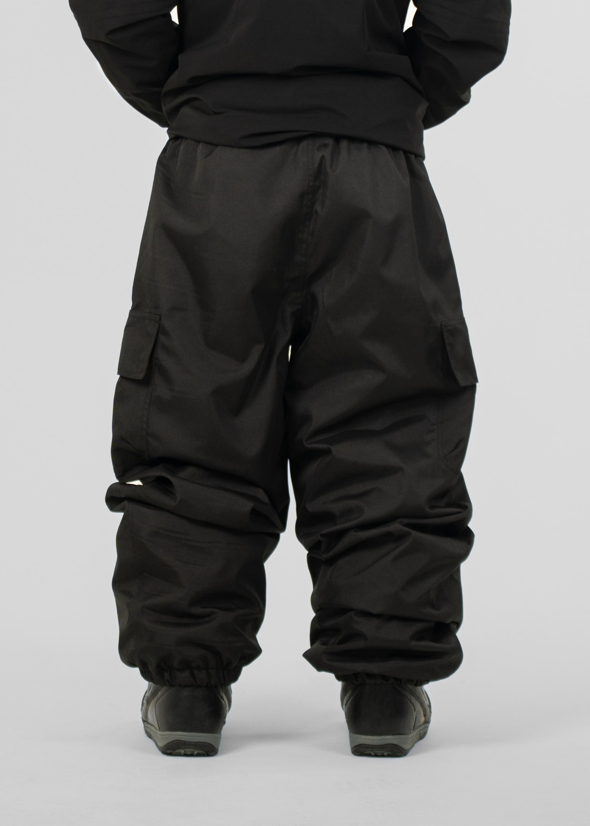 Person wearing black Polar Pursuit snowpants on a plain background
