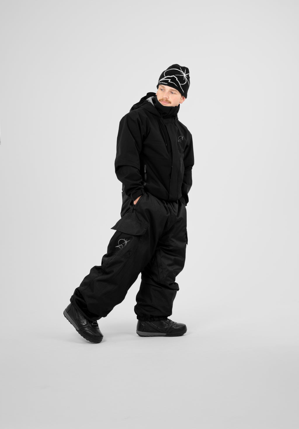 Person wearing a black Polar Pursuit snowsuit and Polar Pursuit hat on a white background