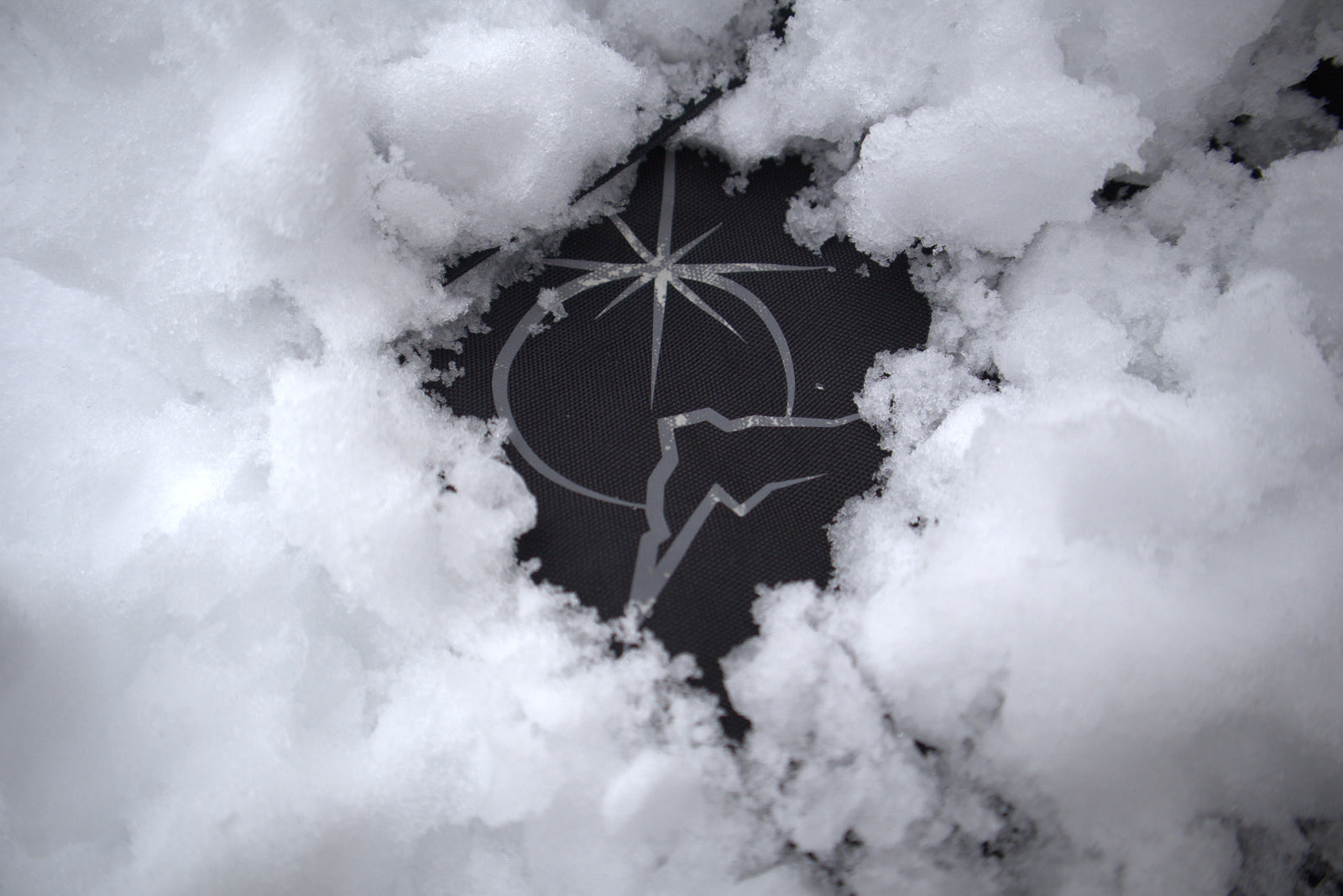 Polar Pursuit logo partially buried in snow